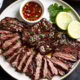 Ein Teller Steak mit einer Schale Dip.