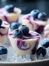 Heidelbeerbissen auf weißem Teller.