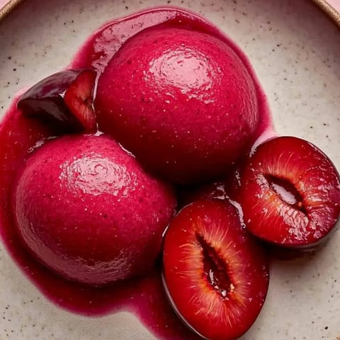 Ein Teller mit Früchten und einer Kirsche obendrauf.