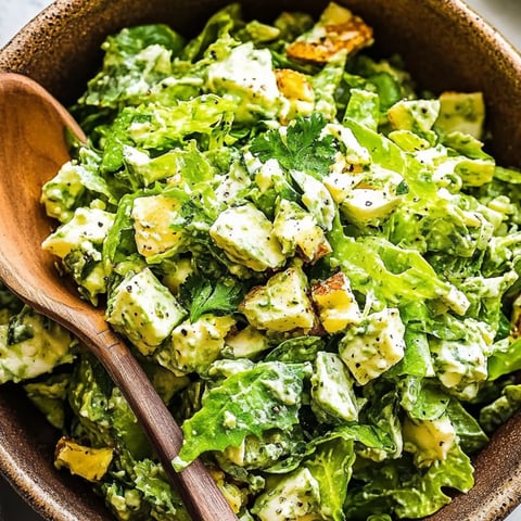 Eine Schüssel Salat mit Holzlöffel.