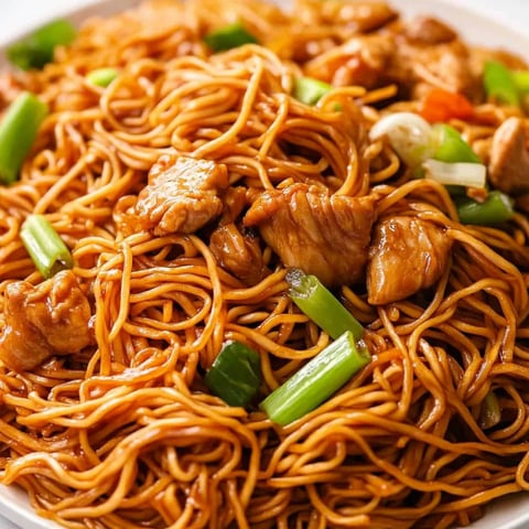 Ein Teller mit Nudeln, Fleisch und Gemüse.