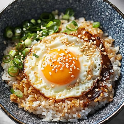Eine Schale Reis mit einem Ei obendrauf.