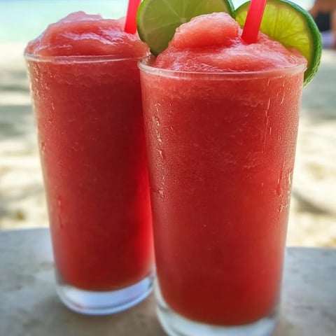 Zwei Gläser roter Drink mit Limetten.