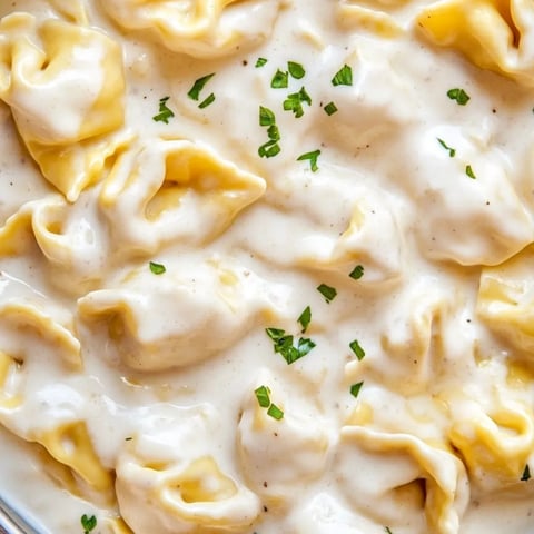 Eine Schüssel Pasta mit grünen Kräutern obendrauf.