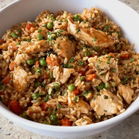 Hühnchen, Reis und Gemüse in einer Schale.