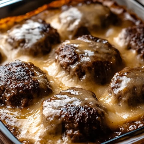 Eine Pfanne voll Hackbällchen mit Käse überbacken.