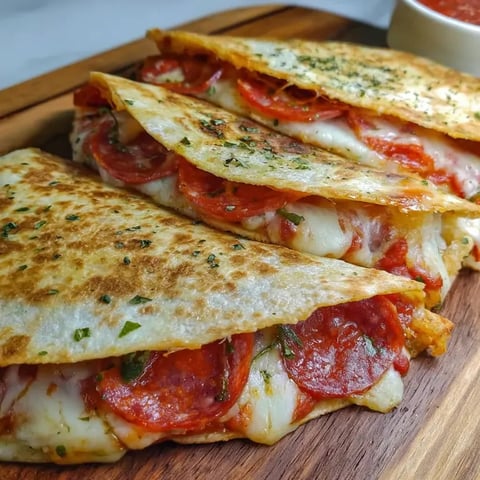 Zwei Stücken Pizza auf einem Holzbrett.