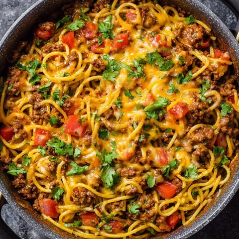 Eine Schale Spaghetti mit Fleischsoße und Tomaten.