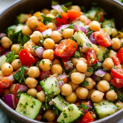Gemüseschale mit Tomaten, Gurken und Kichererbsen.